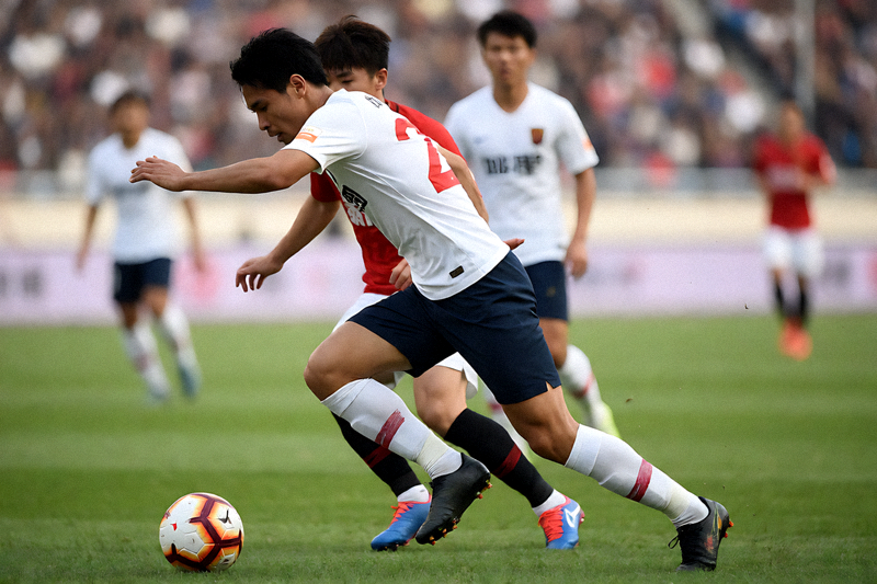 足球比赛中球员在中场拼抢的现场画面